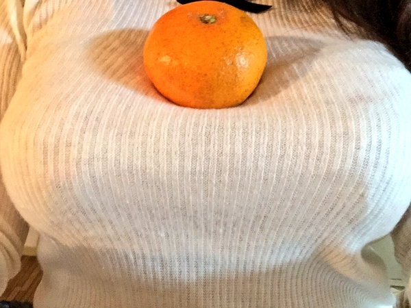 一名日本女網友把自己的胸部當成桌子，把橘子放在上面，不少網友看到後直呼：太犯規了。（圖／翻攝自推特）