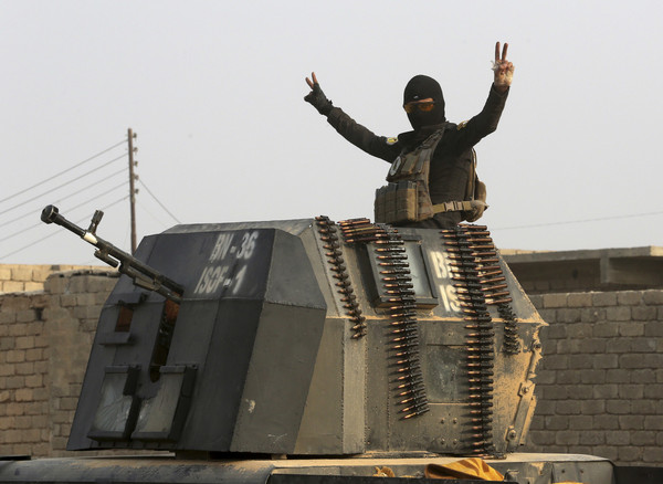 伊拉克反恐部隊26日掃蕩摩蘇爾外圍獲得豐碩戰果。圖為裝甲運兵車上的一名士兵秀年勝利的手勢。(（圖／達志影像／美聯社）