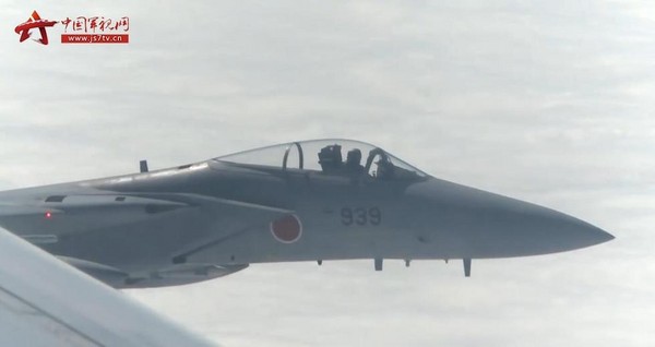 大陸網站曝光10日解放軍戰機遭日本F-15J干擾視頻，畫面顯示日本空自939號F-15J離解放軍戰機「非常近」，甚至能清楚看到對方的飛行員的面貌。（圖／翻攝自中國軍視網）