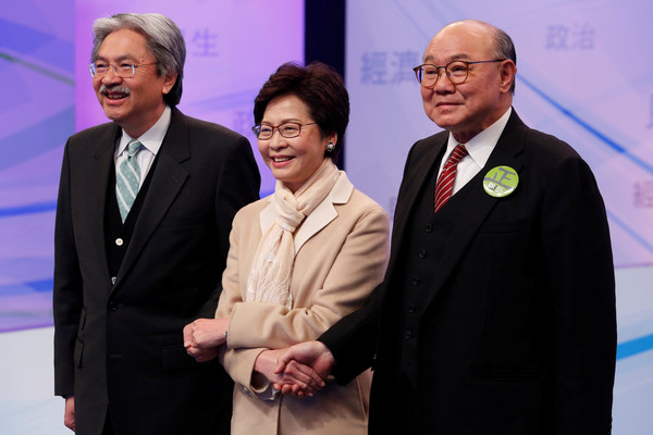 香港特首選舉候選人曾俊華（左）、林鄭月娥（中）、胡國興（右）15日晚間出席特首選舉辯論電視轉播。（圖／路透社）