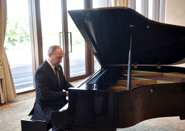 普丁（Vladimir Putin）彈鋼琴。（圖／路透社）