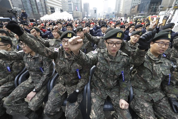 一群韓國軍人在紀念議式中一起喊口號。同性戀在南韓並不違法，但軍方仍可以「影響士氣」為由，依軍法刑起訴。（圖／達志影像／美聯社）