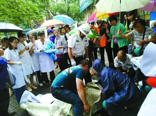 ▲路人們冒雨在街上為婦人搭建臨時產房。（圖／翻攝自中國青年網）