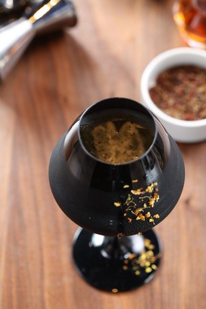 名叫「花花世界」，卻用看不透的黑色杯子盛裝，是Ming的巧思，湊近先聞桂花香，入喉則是融合花椒、綠茶、青蘋果等草本氣息的琴酒。（350元／杯）