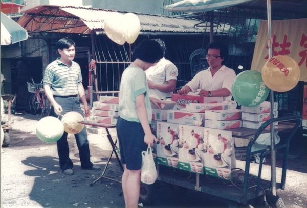 1988年，王正明帶著公司員工在菜市場推廣桂冠水餃，標榜買3盒送1顆海灘球。（桂冠提供）