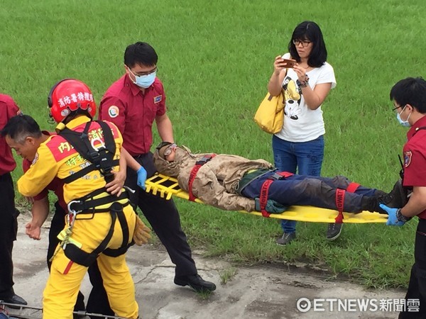 搜救人員以黑鷹直升機將李明翰吊掛救出後，躺在擔架上由消防人員送往慈濟醫院急救。（圖／記者王兆麟攝）