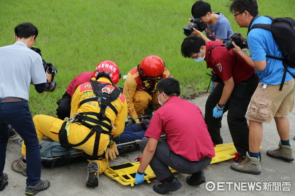 搜救人員以黑鷹直升機將李明翰吊掛救出後，躺在擔架上由消防人員送往慈濟醫院急救。（圖／記者王兆麟攝）