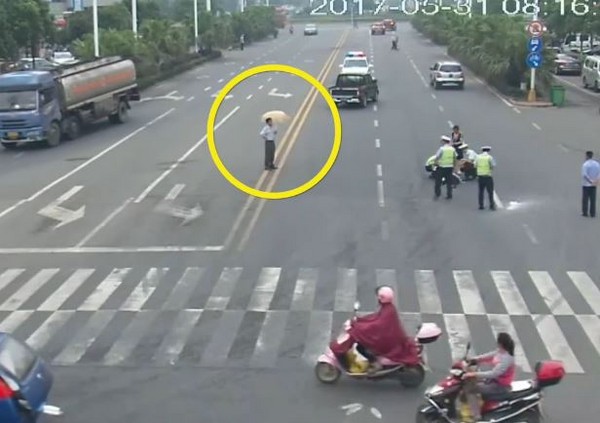 貨卡車撞飛老婦,大叔撐傘站路中央看熱鬧。(圖/翻攝自梨視頻)