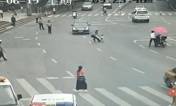 小孩穿越馬路被撞剎那，交警捨命飛撲。（圖／翻攝自梨視頻）