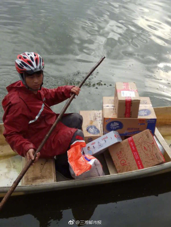 ▲湖南大雨 快遞小哥划船送貨。(圖/翻攝自三湘都市報)