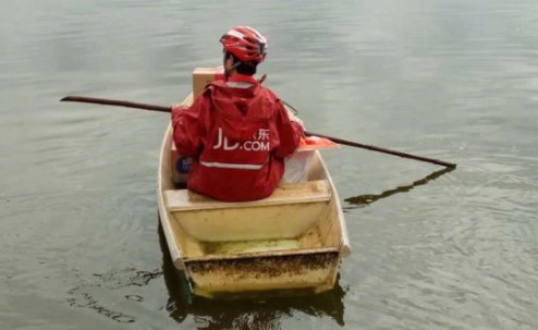 ▲湖南大雨 快遞小哥划船送貨。(圖/翻攝自三湘都市報)