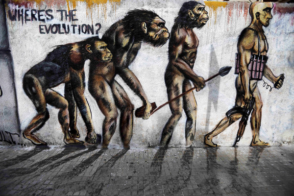 ▲▼位於中東的黎巴嫩戰亂頻繁，牆上畫著英國生物學家達爾文所提出的「演化論」，並多加上了一些武器。（圖／達志影像／美聯社）