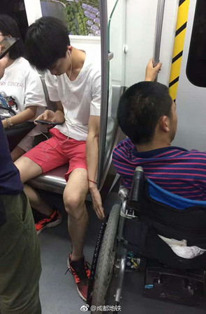 ▲▼一名男子在電車上滑手機，另一手卻做出暖心舉動。（圖／翻攝成都地鐵微博）