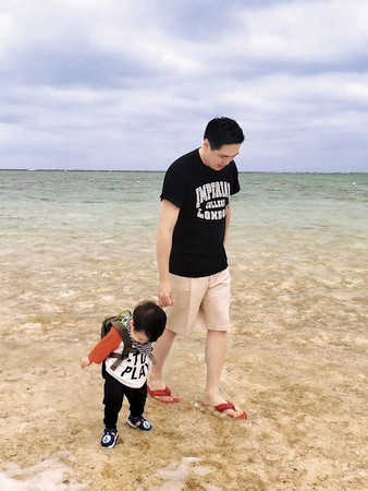 2016年中，麻衣曬出王泉仁牽著小孩在沖繩海灘的照片，父愛滿滿。（翻攝自麻衣臉書）