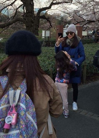 郭台銘夫人曾馨瑩帶著女兒在櫻花樹下拍照。