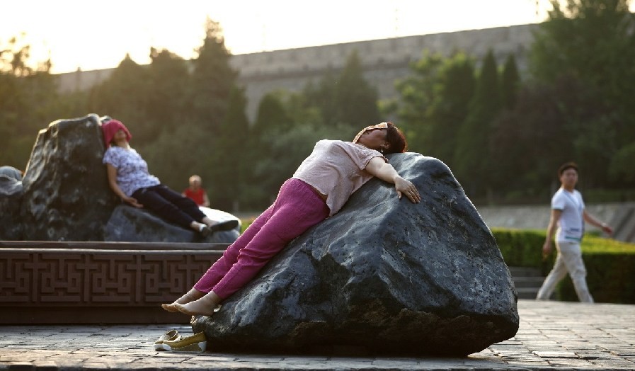 ▲中國大媽躺在西安環城公園3塊大石頭上。（圖／翻攝自微博）