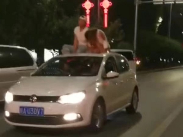 ▲▼中國西安一對男女坐在車頂上「兜風」。（圖／翻攝自「畅通西安」微博）