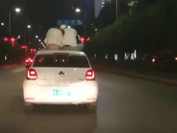 ▲▼中國西安一對男女坐在車頂上「兜風」。（圖／翻攝自「畅通西安」微博）