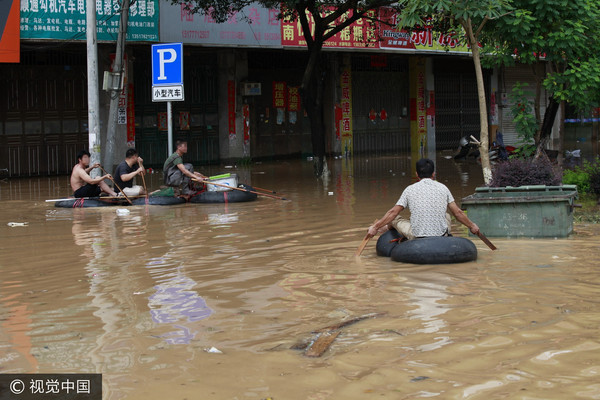 ▲▼2017年7月3日，廣西柳州市雒容鎮的街道被倒灌洪水淹沒，居民乘坐充氣艇在積水路段電魚。（圖／CFP）