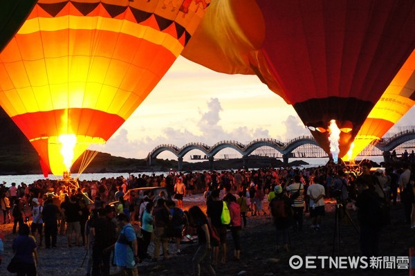 台東縣政府辦理的熱氣球嘉年華第二場光雕音樂會，於成功鎮三仙台舉行，熱氣球與曙光及升起的日出相輝映，讓觀眾驚呼連連。（圖／台東縣政府提供）