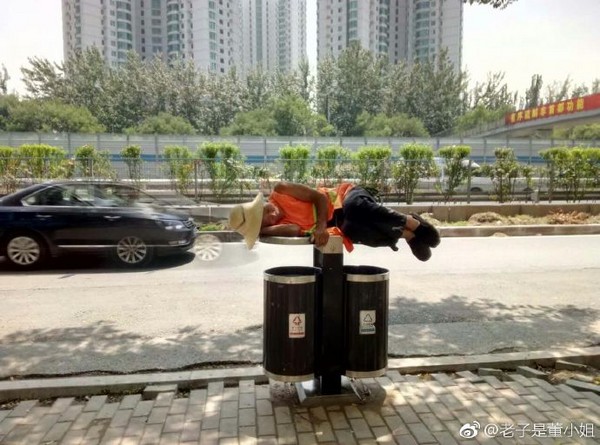 ▲▼北京一名綠化工人躺在垃圾桶蓋上休息。（圖／翻攝老子是董小姐微博）