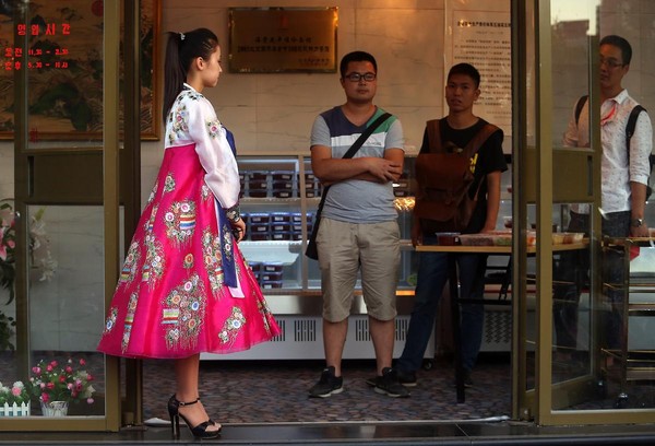 中國北京，一家北韓餐館門前，身穿朝鮮民族服飾的美女正在迎賓。北韓在海外的餐館連鎖店也是金正恩政權獲取資金的重要來源。（東方IC）