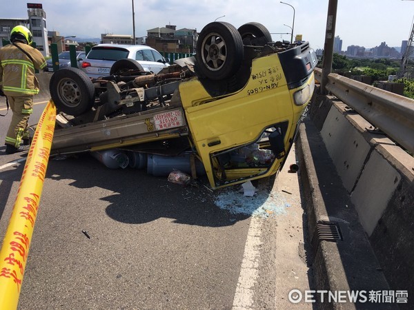 萬華區環河快速道路往南方向、桂林路匝道口，一輛運瓦斯鋼瓶小貨車翻覆。（圖／記者柳名耕翻攝）