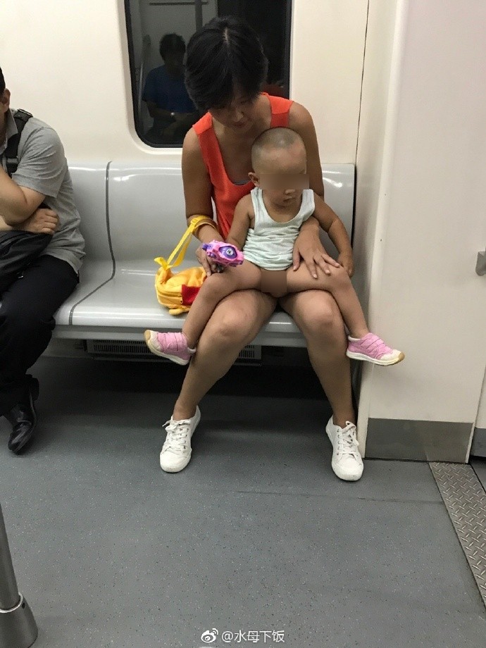 ▲▼天津地鐵上年輕媽媽幫小孩把尿。（圖／取自微博）