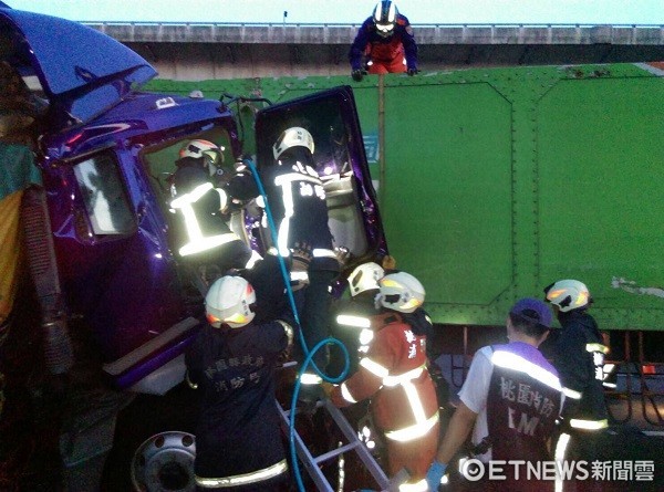 ▲▼國道１號北上聯結車車禍，消防人員正全力搶救受困車內駕駛。（圖／桃園市消防局提供））