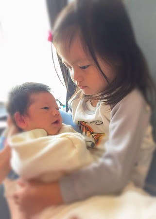 ▲大女兒蕾蕾溫柔抱著弟弟YOLO，幸福畫面感動宥勝。（圖／翻攝自宥勝臉書）