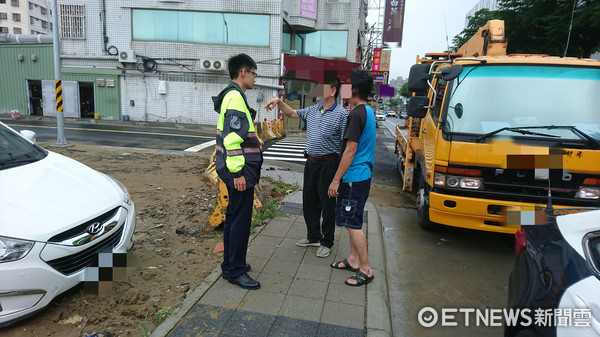 ▲颱風過境南市豪雨造成地面泥土濕軟，一名邱姓民眾轎車前輪陷入泥濘之中，無法動彈，經向台南市警一分局莊敬所警員蔡宇杰、郭銘斌求助。（圖／警方提供）