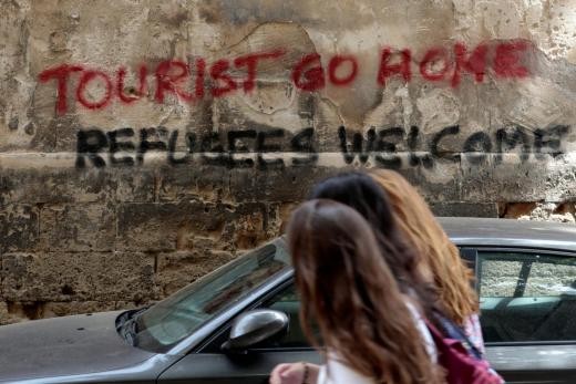 ▲▼ 西班牙旅遊業發達，但人民卻出現反彈聲浪，牆上的塗鴉寫著「遊客滾回家，只歡迎難民」。。（圖／路透社）