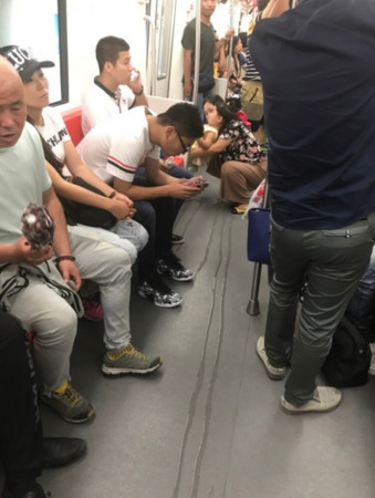 ▲▼哈爾濱一名媽媽抱著孩子蹲在火車車廂尿尿。（圖／翻攝偽叔微博）