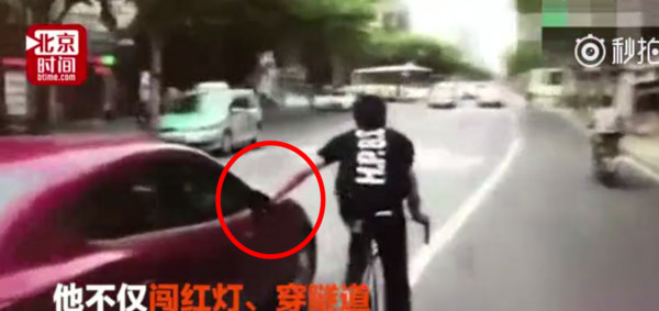 ▲▼上海一名男高中生騎著單速車在路上狂飆蛇行，還壓下轎車的後照鏡。（圖／翻攝自《北京時間》）