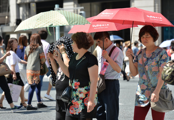 ▲日本上周持續出現高溫，大街上呈現現一片「傘海」。(圖／達志影像／美聯社)