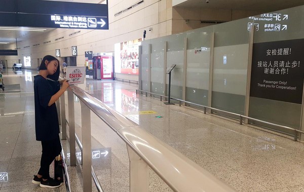 一位手拿「TSMC（台積電）」看板的工作人員，等待著來自台灣的工程師。