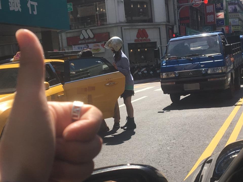 桃園市一名女騎士發現一名行動不便的婦人卡在路中間，立刻下車幫忙扶對方上計程車。路過駕駛見狀拍下暖心過程，伸出車窗對女騎士比「讚」。（圖／翻攝「爆料公社」臉書社團）