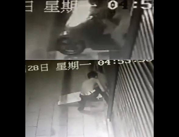 ▲福建省仙遊縣榜頭鎮一名男子趁一家店主騎車離開時，想闖入偷東西，但對方的鐵捲門竟緩緩下降，讓他心急得進出不得，自作聰明的用腳仙卡住，沒想到這一卡，就讓他躺在地上等警察來抓人。。（圖／翻攝梨視頻）