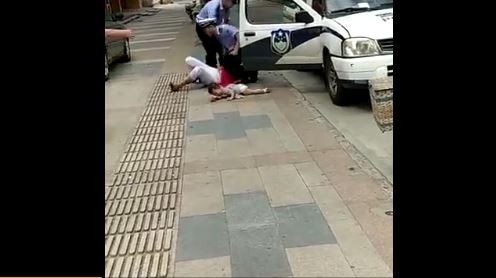 陸女抱娃被警重摔，女童拋飛撞地大哭。（圖／翻攝自北京青年報微博）