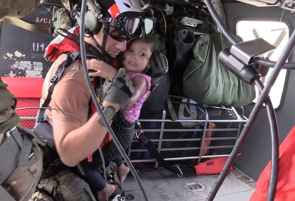 ▲▼美國空軍第106航空救援隊於1日在德州休士頓救災，其中一名成員抱起一名小女孩。（圖／路透社）
