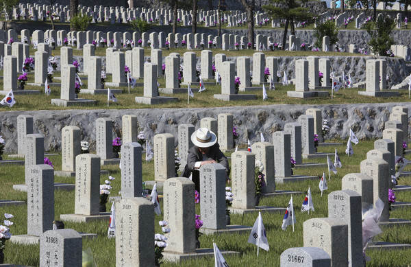▲▼一名韓國人在他於韓戰中身亡的家人墓碑前致意。（圖／達志影像／美聯社）