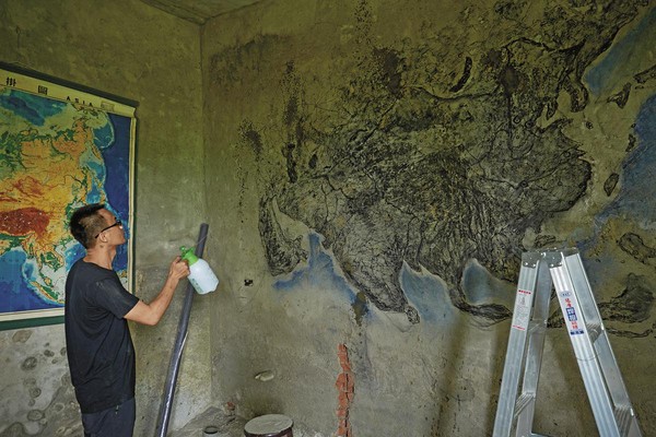 高俊宏以掛圖為藍本，在水泥牆面繪出如發霉紋路般的東亞地圖。（汯呄霖電影提供）
