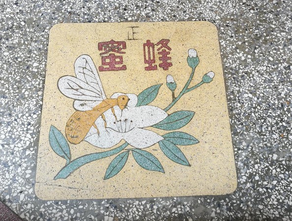 「迪化207博物館」外頭，地面鑲嵌有蜜蜂採蜜的磨石子。