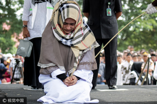 ▲印尼亞齊特區（Aceh）一名女子與男子聊天，犯下通姦罪鞭刑100下。（圖／CFP）