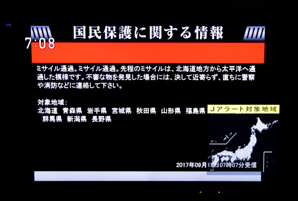 北韓15日又發射導彈，飛過北海道上空，東京街頭電視播放避難警報。（圖／路透社）