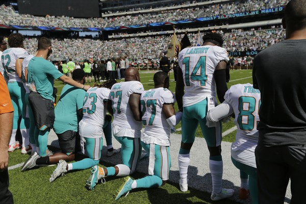▲▼NFL的球員在唱國歌時下跪表達對川普的抗議。（圖／美聯社）