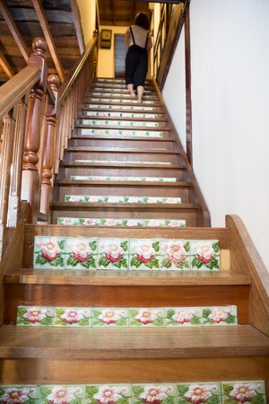 新屋主以老工法打造木樓梯，花磚朵朵開滿階梯。