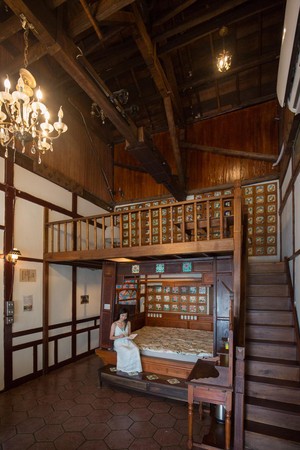 古厝2樓擺設大型花磚家具，這張紅眠床的床楣和腳蹬都妝點花磚。