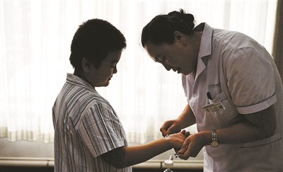 ▲▼護士替小學4年級的江樂擦去墨水。（圖／翻攝自《北京青年報》）