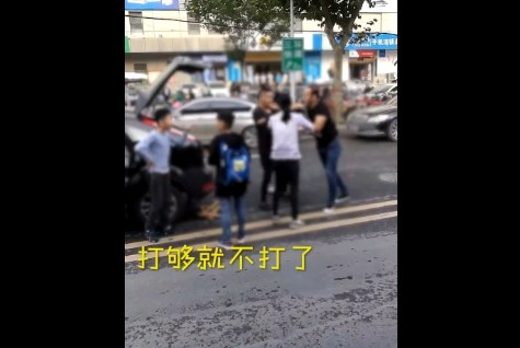 ▲▼河南鄭州日前有兩輛轎車發生擦撞，車主在街頭鬥毆，一名車主的孩子在旁邊勸架，另一名車主的孩子則淡定觀戰。（圖／翻攝《梨視頻》）